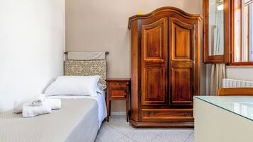 Ein Hotelzimmer mit einem Bett, einem Holzschrank, einem Nachttisch und einem Spiegel.