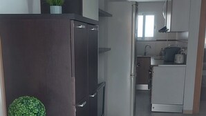 A modern kitchen with a dark wooden cabinet, a built-in oven, and a small sink. - ELITE apartment 200 meters from the beach (Cullera)