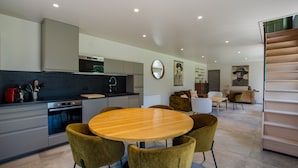 Una cocina moderna con comedor, que incluye una mesa redonda de madera y cuatro sillas.