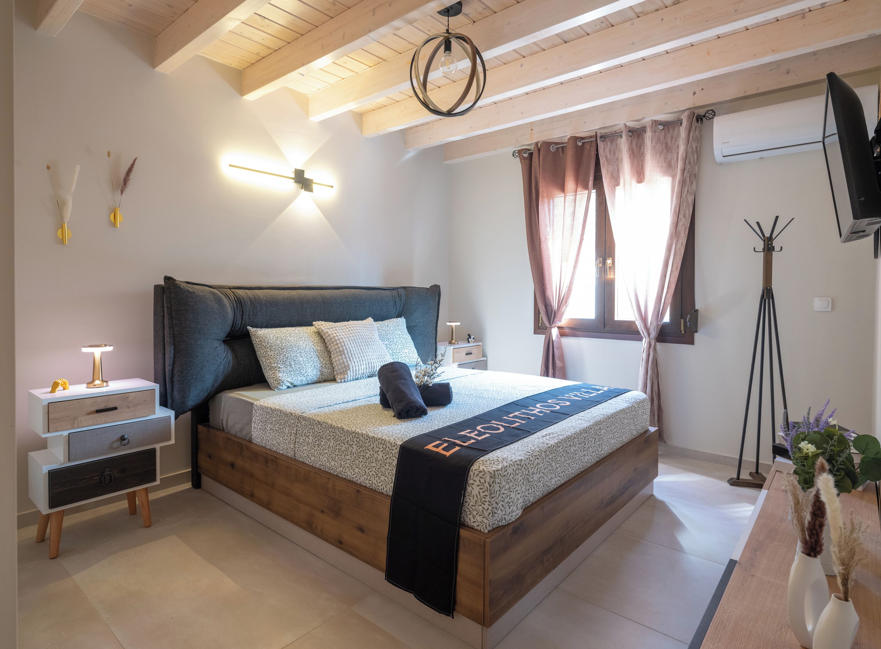 Une chambre à coucher moderne avec un lit en bois, une table de chevet, une lampe et une vue sur l’extérieur.