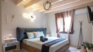 A modern bedroom with a wooden bed, a bedside table, a lamp, and a view of the outdoors.