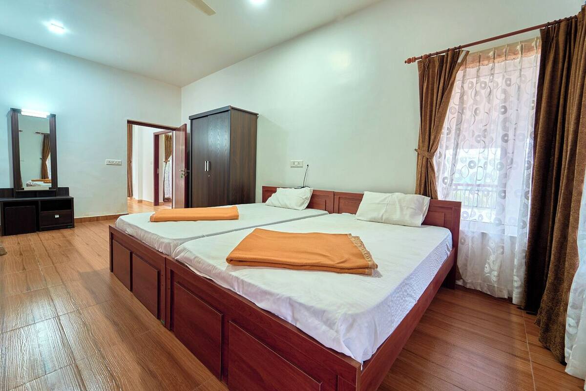 Une chambre avec un grand lit, une armoire et un miroir.