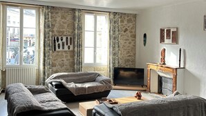 Une chambre avec deux lits, une télévision et une cheminée.