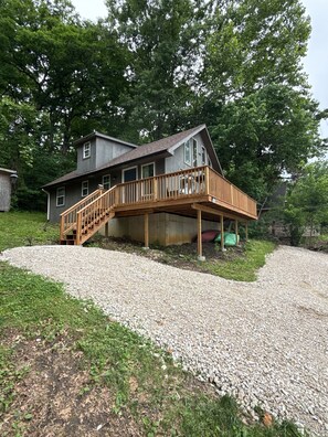 A two-story house with a wooden deck and a gravel driveway. - Digital Detox Cabin, Wi-Fi hotspot available for add on, Boat Ramp access across the street (Roach)