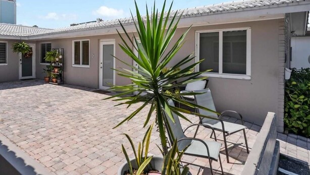 A residential building with a tiled roof, a paved courtyard, and potted plants. - Octopus Sanctuary · Steps from the Beach! (Hollywood)