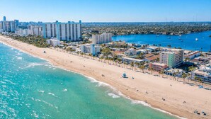 A coastal cityscape with a beach, high-rise buildings, and a marina. - Octopus Sanctuary · Steps from the Beach! (Hollywood)