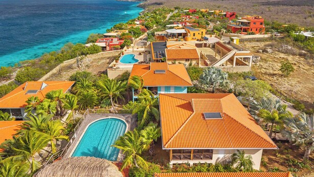 A coastal resort with multiple buildings, a swimming pool, and a view of the ocean. - Villa Happy Turtle with a spectacular ocean view (Kralendijk)