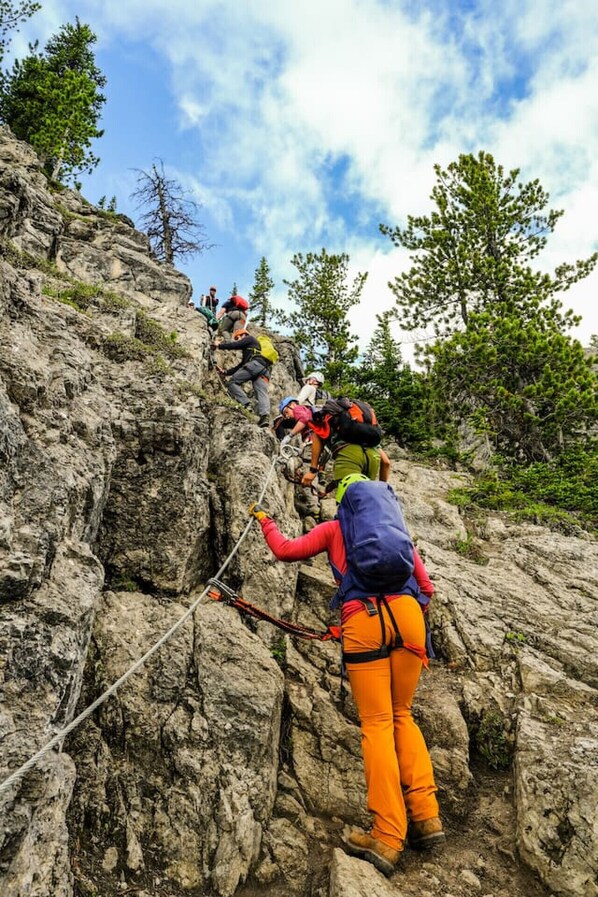 Un grupo de excursionistas subiendo por un sendero pedregoso en la montaña.