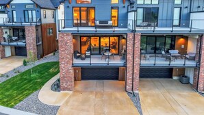 Een modern huis met twee verdiepingen, een overdekte patio en een garage.