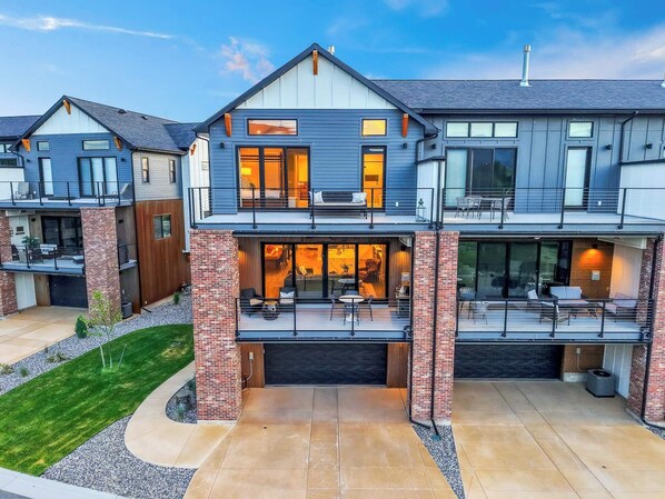 A modern two-story house with a covered patio and a garage.