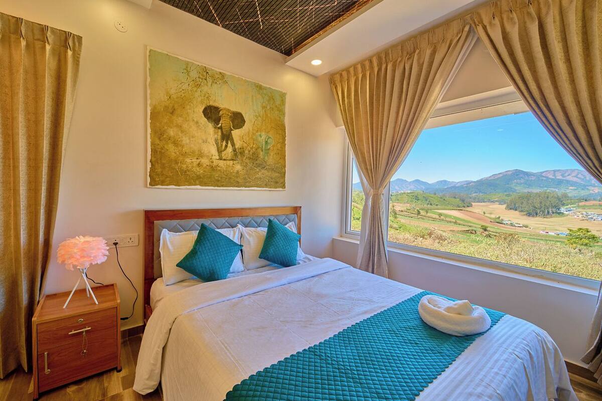 Un dormitorio con una cama grande, vistas al campo y un cuadro en la pared.
