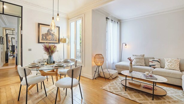Un salon moderne avec une table à manger en verre, des sièges confortables, un canapé et une table basse.