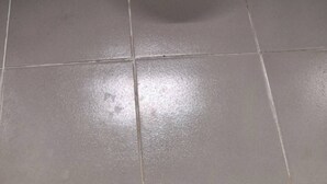 A white toilet in a bathroom with tiled walls and floor.