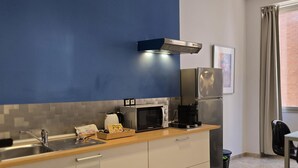A compact kitchen with a microwave, coffee maker, and kettle on the counter. - Design Suites in Malaga Center - Comfortable Accommodation (Málaga)