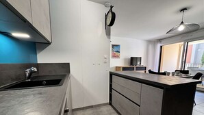 Una cocina moderna con un lavamanos integrado, un reloj y un comedor con mesa y sillas.