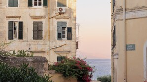 Un bâtiment doté de nombreuses fenêtres, dont certaines sont équipées de volets, et d’une enseigne indiquant un lieu.