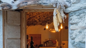 Een landelijke keuken met houten kasten, een stenen muur en oren mais.
