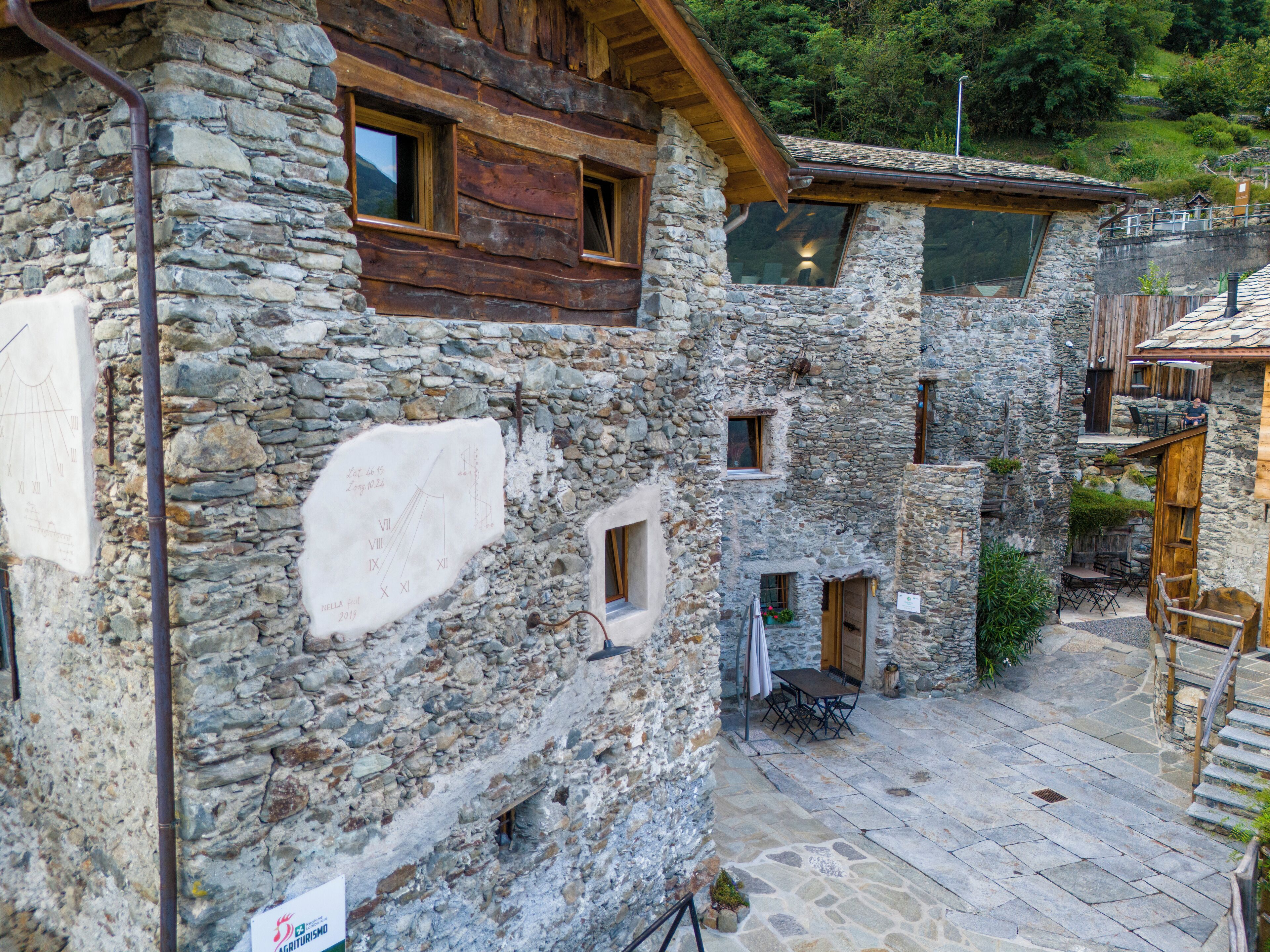 A stone building with multiple windows and a wooden staircase.