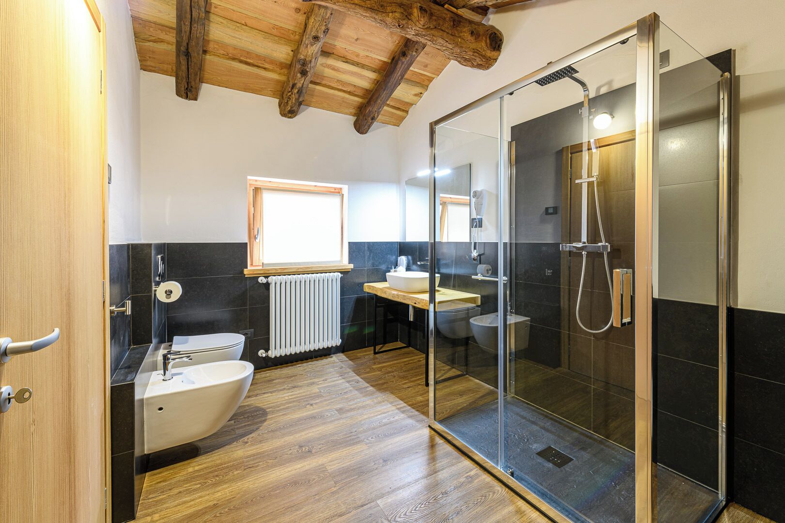 Un baño moderno con ducha de vidrio, lavamanos independiente y un inodoro.