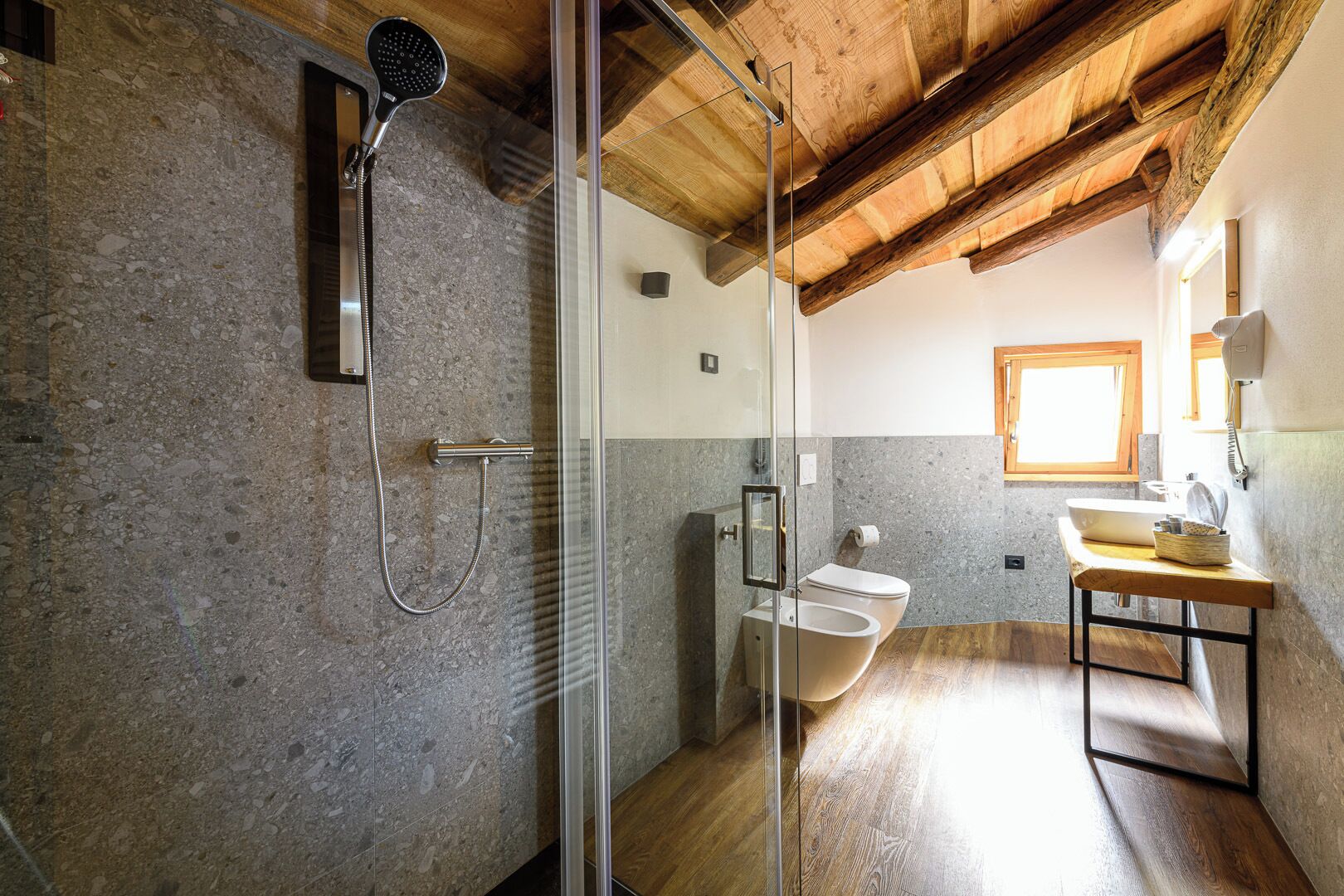 A modern bathroom with a shower, toilet, and sink.