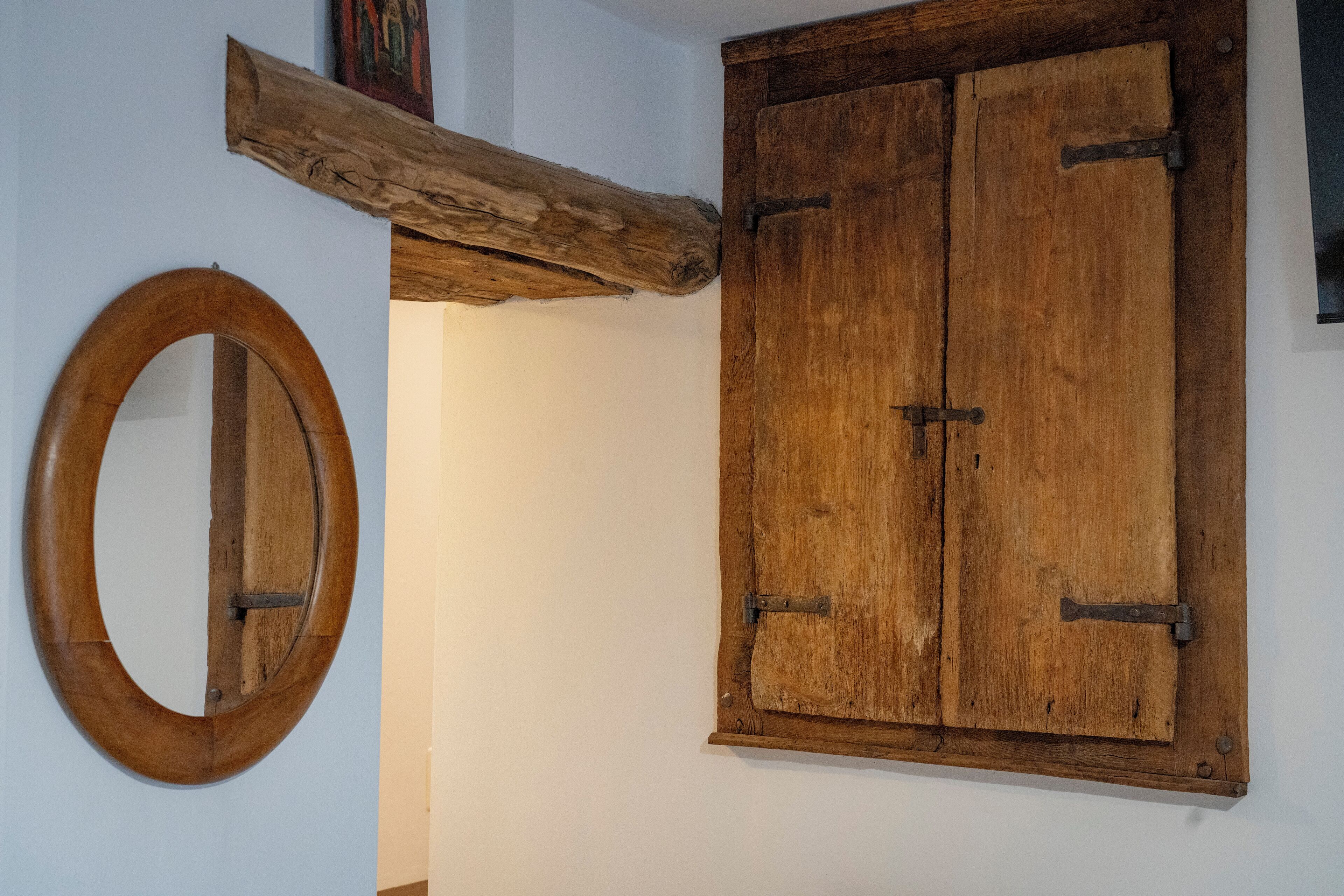 Une pièce rustique avec un meuble en bois et un miroir encadré de bois.