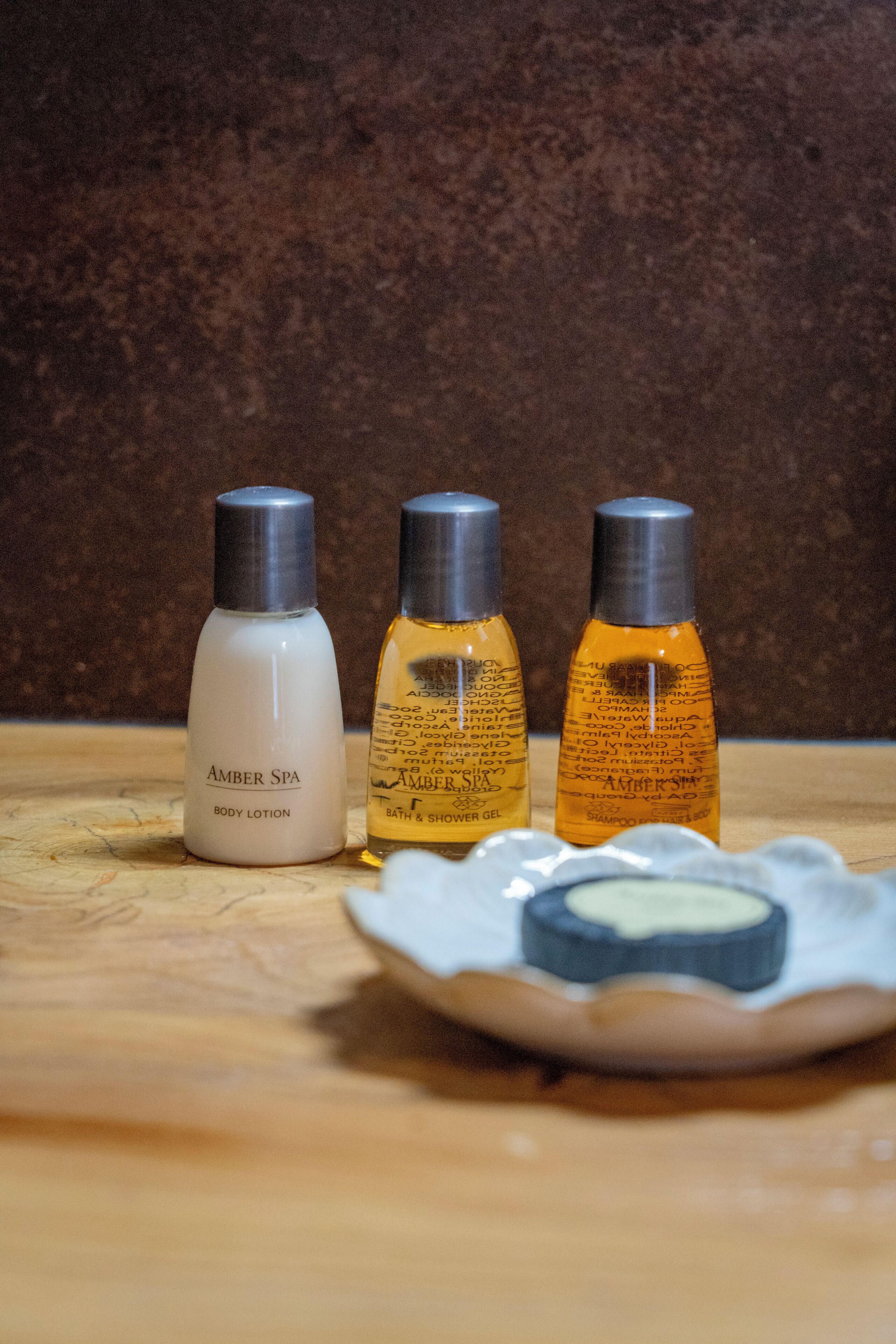 Three bottles of body lotion on a wooden surface.