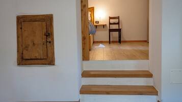 Een trap die leidt naar een slaapkamer met een houten deur en een stoel.