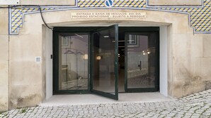 Entrada de un edificio con un letrero que indica restricciones para la entrada y salida de vehículos.
