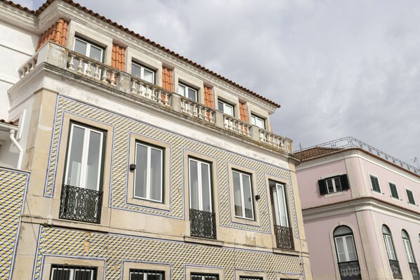 Un edificio con fachada decorativa, varias ventanas y balcones.