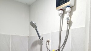 Ducha con panel de control digital, cabezal de ducha manual y manguera flexible.