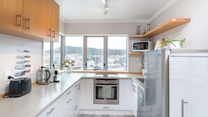 A modern kitchen with a view, stainless steel appliances, and wooden cabinets.