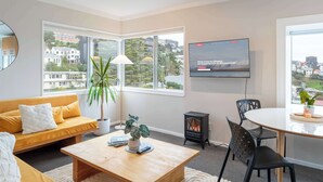 A modern living room with a sofa, coffee table, TV, and a fireplace.