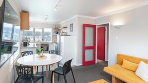 A modern apartment with a dining area, kitchen, and living space.