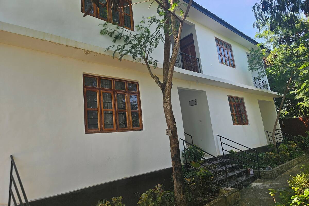 A two-story building with large windows and a staircase leading to the entrance.