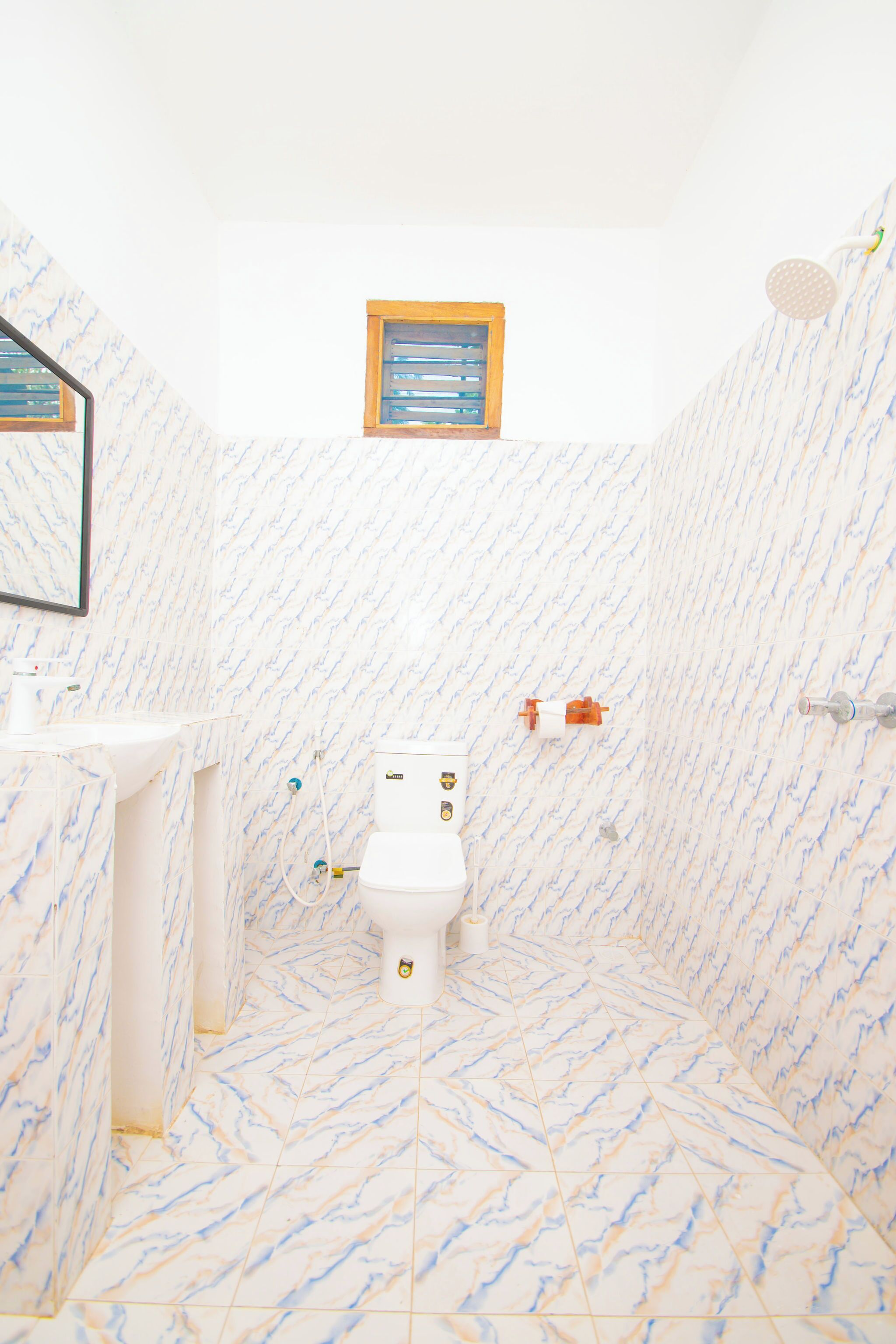Un baño con inodoro, lavamanos y ducha.