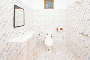 A bathroom with a marble floor, a toilet, a sink, and a shower. - Kigwedeni Apartments (Nungwi)