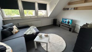 Een moderne woonkamer met een bank, een salontafel en een televisie.