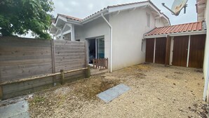 Il s'agit d'une propriété résidentielle dotée d'une cour en gravier, d'une clôture en bois, d'une antenne parabolique et d'un garage avec des portes en bois.