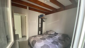 Une chambre à coucher avec un lit, une porte et une fenêtre.