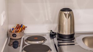 Eine Küche mit einem Toaster, einem Wasserkocher und einer Schüssel mit Besteck.