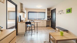 A compact kitchen with a dining area, a bench, and a small table. - "L'escale du Goelo" in Paimpol, close to beaches (Paimpol)