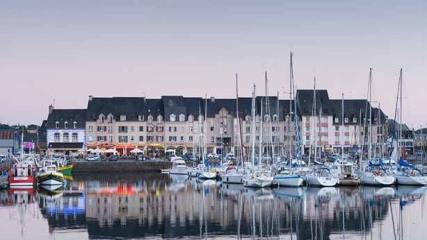 A marina with multiple boats docked in calm waters, surrounded by multi-story buildings with commercial establishments. - "L'escale du Goelo" in Paimpol, close to beaches (Paimpol)
