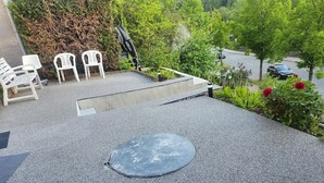 A rooftop terrace with a circular seating area, a small table, and a few chairs.