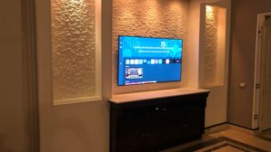 Ein Flachbildfernseher an einer strukturierten Wand in einem Flur.