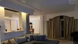 Ein modernes Wohnzimmer mit einer Eckcouch, einem Couchtisch und einem großen Spiegel.