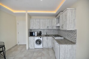 ファミリー コンドミニアム バルコニー | 専用キッチン | 小型冷蔵庫、オーブン、コンロ、調理器具と食器