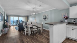A spacious kitchen with a dining area, a ceiling fan, and a view to the outside. - Sandy Key 213:  2 BR/2 BA Perdido Key Beachfront Condo & Pools, On-Site Rental Office, Sleeps 6 (Pensacola)