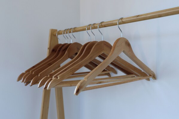 A wooden clothing rack with several hangers.