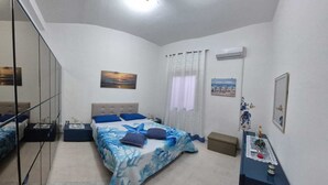 Un dormitorio con dos camas, un espejo y obras de arte en las paredes.