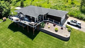 A large, two-story house with a covered patio and a carport. - Black Hills Getaway With Hot Tub Game Room for 18 (Spearfish)